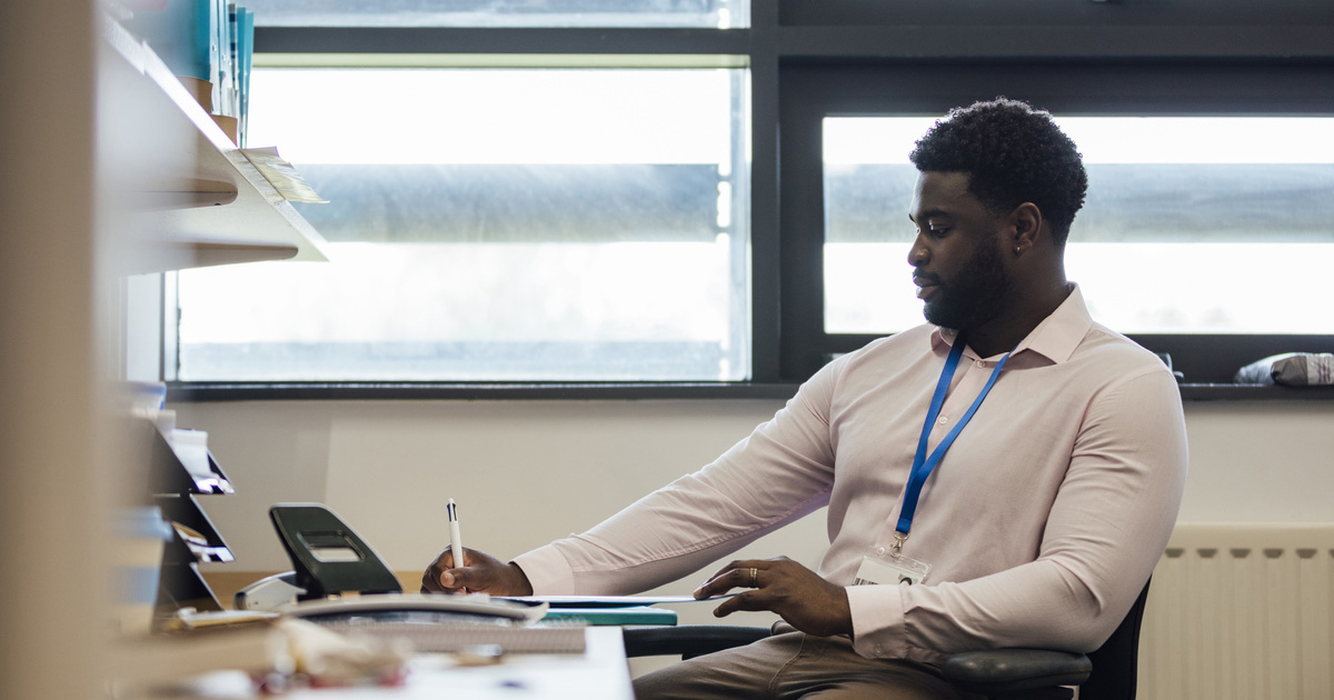 A male teacher works at his desk.