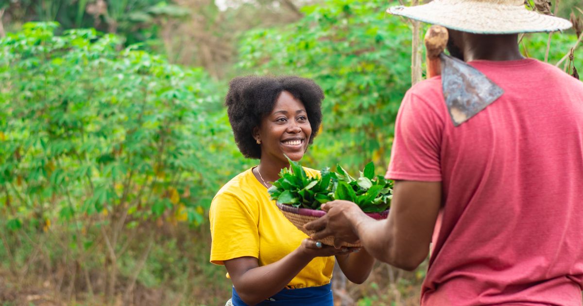 woman taking a basket of vegetable from a man