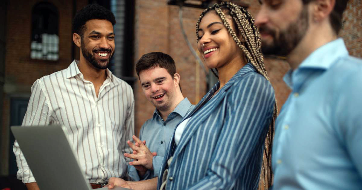 Cheerful young businesspeople with a laptop working in  an office.