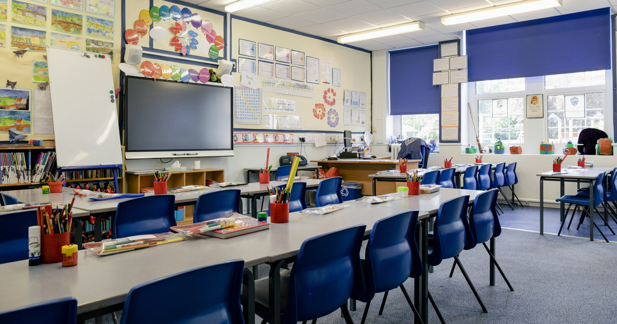 a classroom with blue chairs and a large table